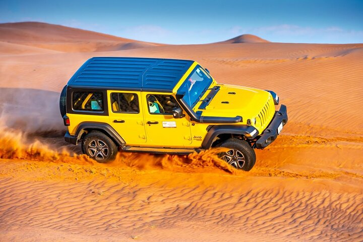 Experience the excitement of dune bashing in a Jeep Wrangler gliding over golden sands while soaking in the beauty of Dubai's desert landscape. Perfect for unforgettable memories!